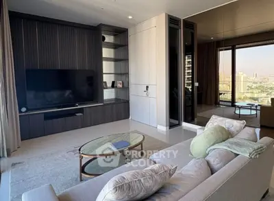 Luxurious modern living room with city view, elegant furniture, and large TV setup.