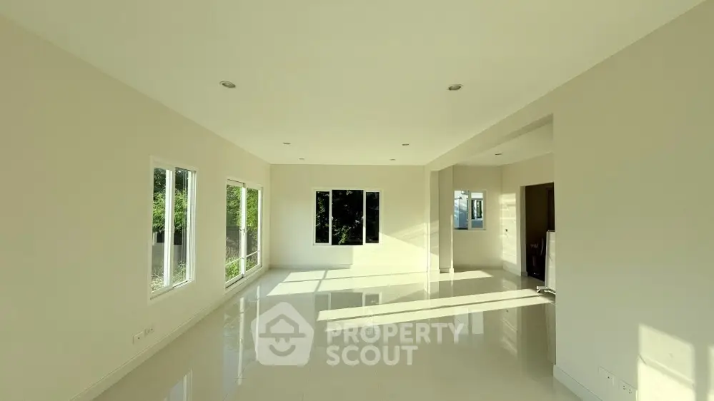Spacious sunlit living room with large windows and sleek modern design