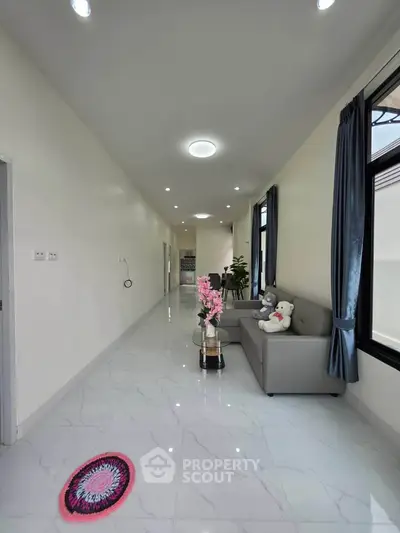Spacious modern living room with sleek tile flooring and cozy seating area.