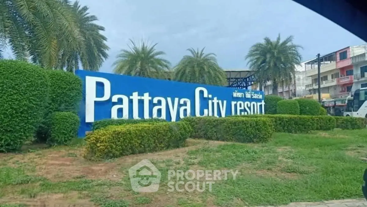 Pattaya City Resort entrance with lush greenery and palm trees, showcasing a welcoming atmosphere.