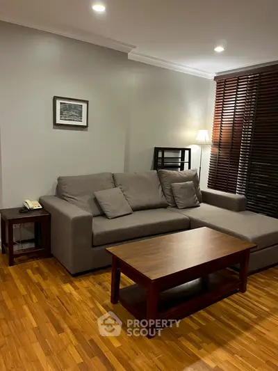 Cozy living room with modern gray sofa and wooden coffee table, perfect for relaxation.