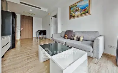 Modern living room with stylish gray sofa and glass coffee table in a cozy apartment.