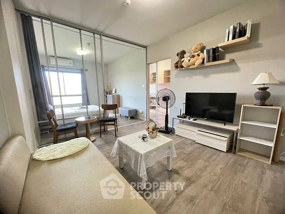 Modern living room with cozy decor and open layout, featuring a TV and stylish furniture.