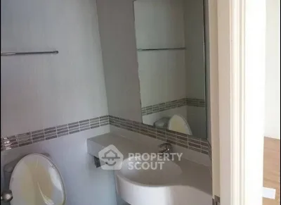 Modern bathroom with sleek sink and large mirror in contemporary home.