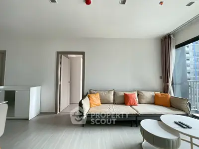 Modern living room with cozy sofa and bright cushions in a stylish apartment.