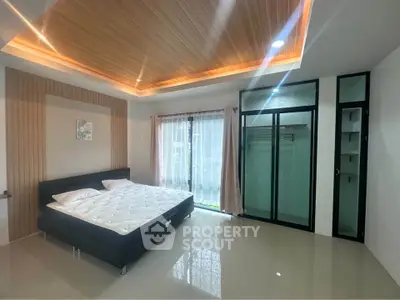 Spacious modern bedroom with elegant ceiling design and large window