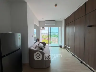 Modern living room with balcony and scenic view, featuring sleek design and ample natural light.