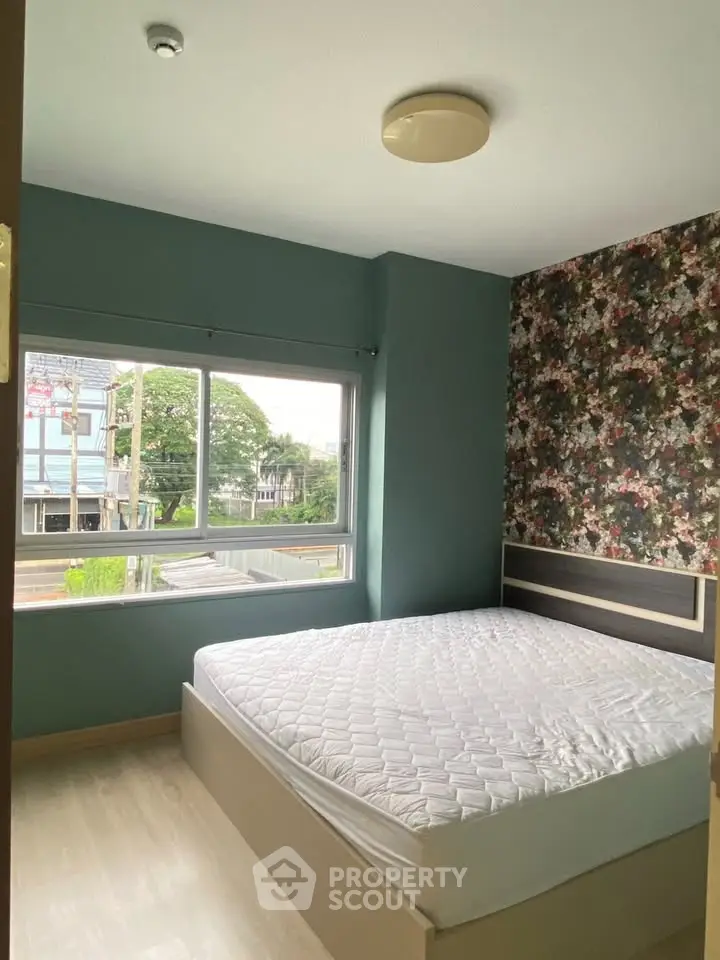 Cozy bedroom with floral accent wall and large window view
