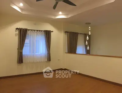 Spacious living room with elegant curtains and modern ceiling fan