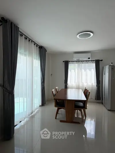 Spacious dining area with elegant curtains and modern furniture, perfect for family gatherings.