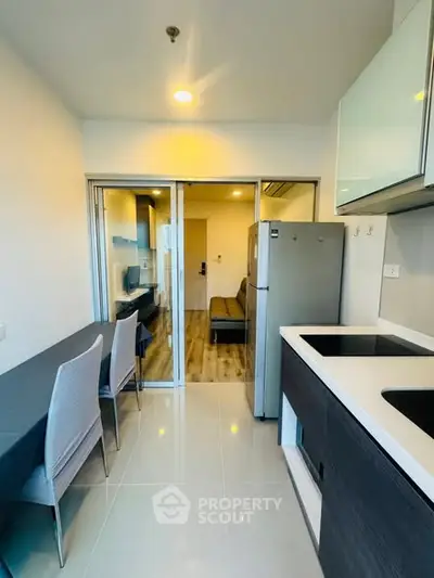 Modern kitchen with sleek design and open layout leading to cozy living area.