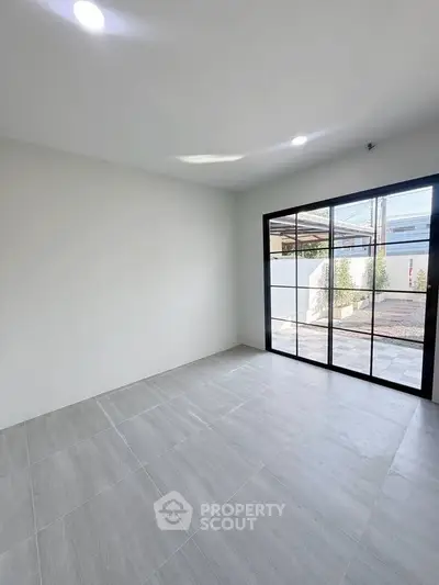 Spacious room with large windows and modern tile flooring, perfect for natural light lovers.