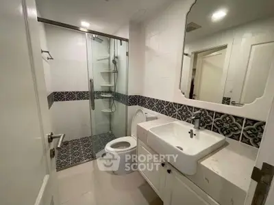 Modern bathroom with stylish tile accents and glass shower enclosure