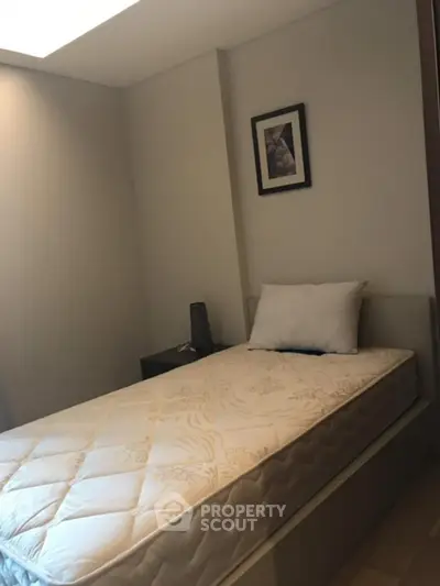 Cozy bedroom with single bed and modern decor, perfect for minimalist living.