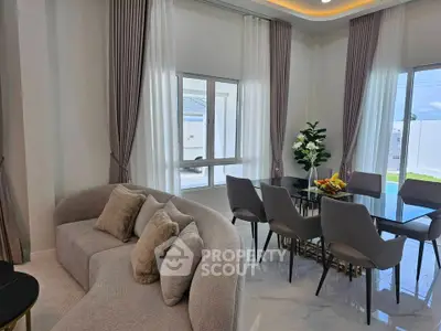 Elegant living and dining area with modern furniture and large windows