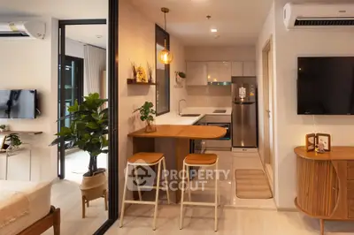 Modern open-layout kitchen with stylish bar stools and cozy living area, perfect for urban living.