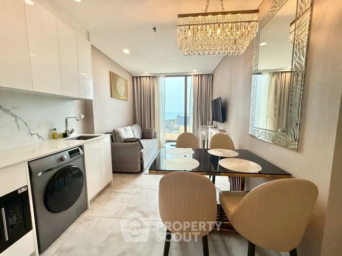 Elegant modern living room with dining area and city view, featuring chic chandelier and sleek furniture.