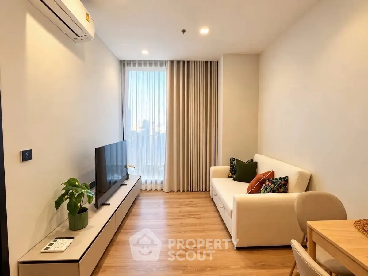Modern living room with cozy sofa and large window offering natural light.