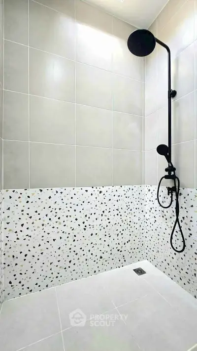 Modern bathroom with stylish terrazzo tiles and sleek black shower fixture