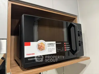 Modern kitchen with sleek Toshiba microwave oven in wooden cabinet