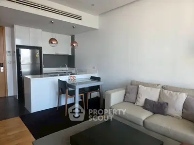 Modern living room with open kitchen and stylish decor in a contemporary apartment.
