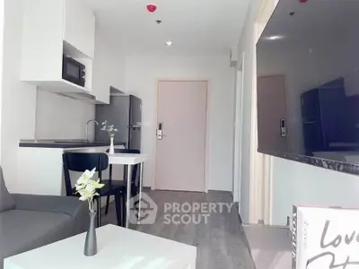 Modern apartment interior with open kitchen and cozy living area, featuring sleek furniture and stylish decor.