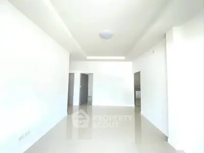 Spacious and bright modern living room with sleek tile flooring and minimalist design.