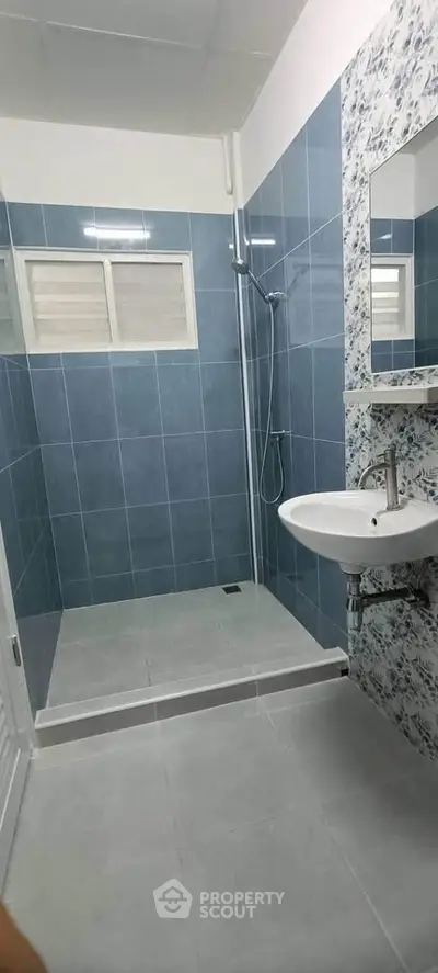 Modern bathroom with blue tiles and sleek shower design