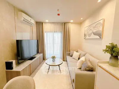 Modern living room with sleek design, featuring a cozy sofa, large TV, and elegant decor.