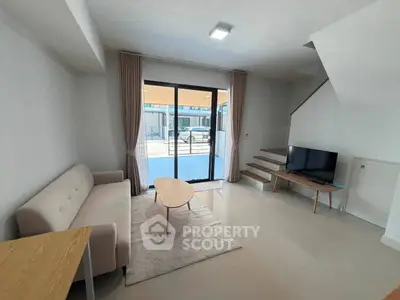 Modern living room with sleek design and natural light, featuring a cozy sofa and stylish coffee table.