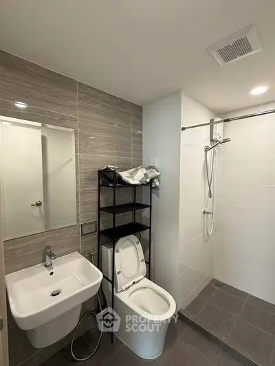 Modern bathroom with sleek fixtures and walk-in shower in contemporary apartment.