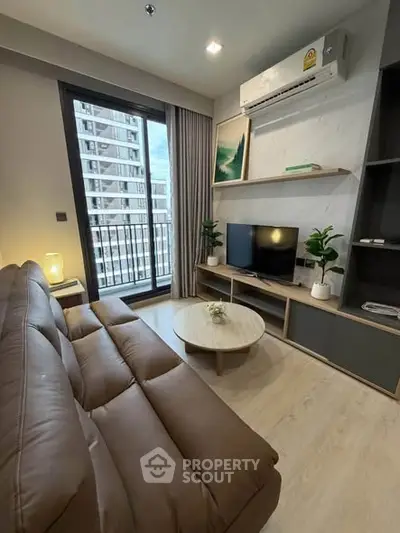 Modern living room with brown leather sofa, TV, and large window with city view.