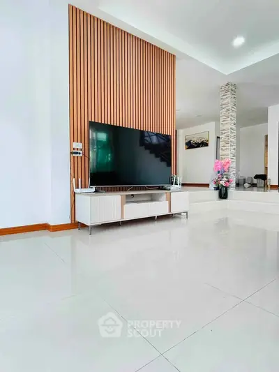 Modern living room with sleek TV setup and stylish wooden paneling