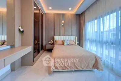 Luxurious bedroom with elegant decor and large windows offering natural light