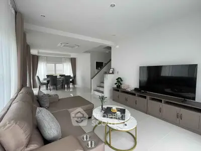 Spacious modern living room with elegant decor and large TV, perfect for family gatherings.