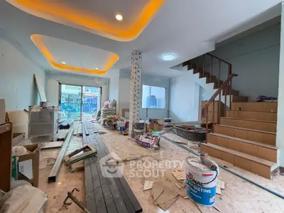 Spacious under-construction living room with modern staircase and ceiling lights