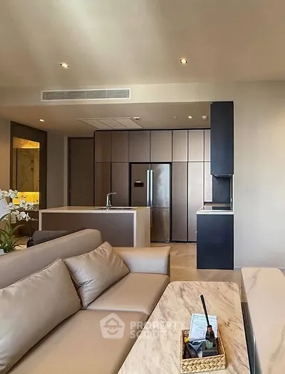 Modern living room with sleek kitchen, featuring open layout and luxurious finishes.