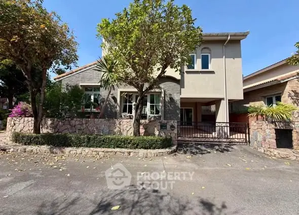 Charming suburban home with lush garden and stone facade, perfect for family living.
