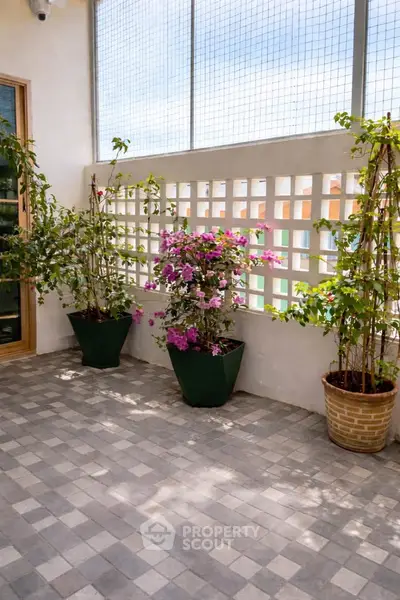 Charming balcony with potted plants and tiled flooring, perfect for relaxation and enjoying fresh air.
