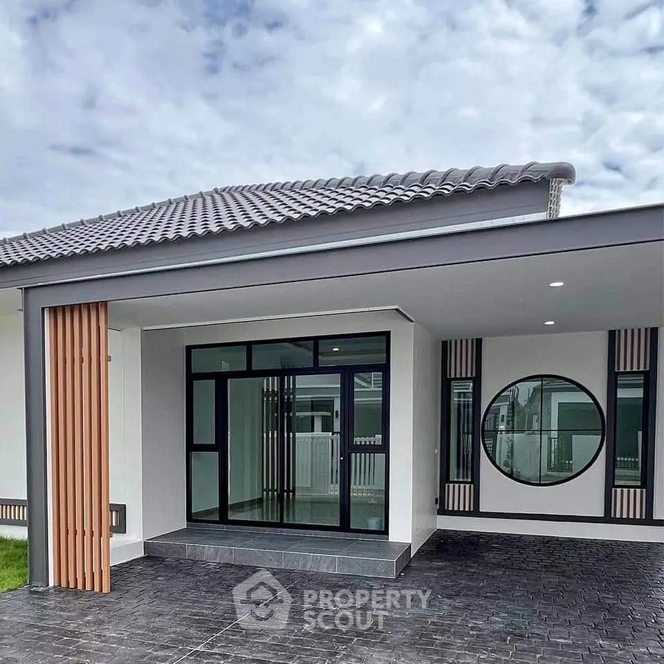 Modern single-story house with sleek design and circular window feature.