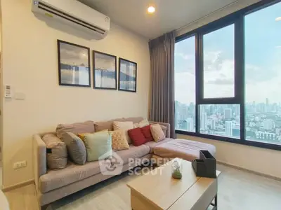Modern living room with city view, cozy sofa, and stylish decor in high-rise apartment.