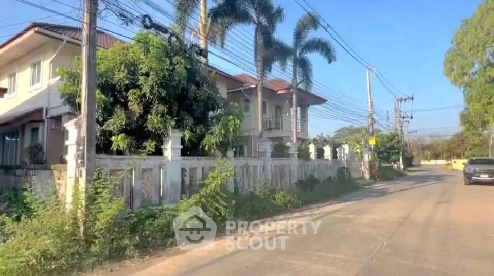Charming suburban house with lush greenery and palm trees, perfect for tranquil living.