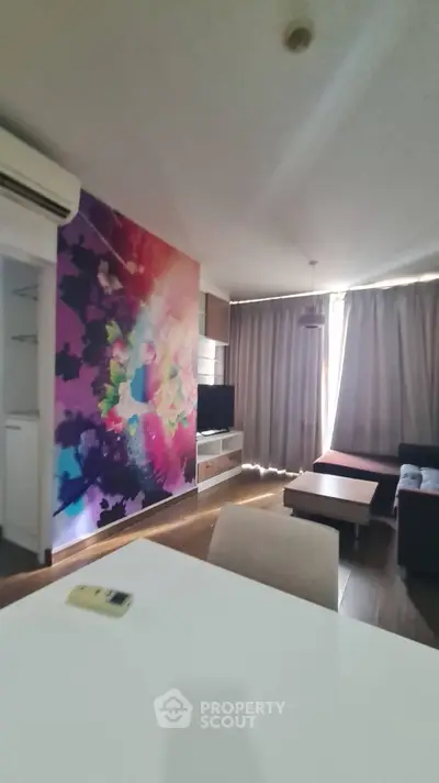Modern living room with vibrant wall art and cozy seating area