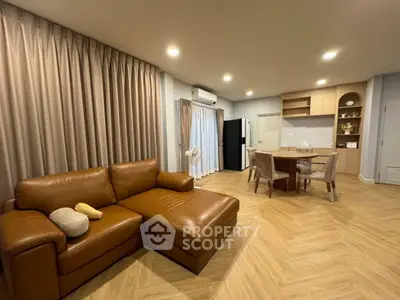Spacious living room with modern leather sofa and dining area