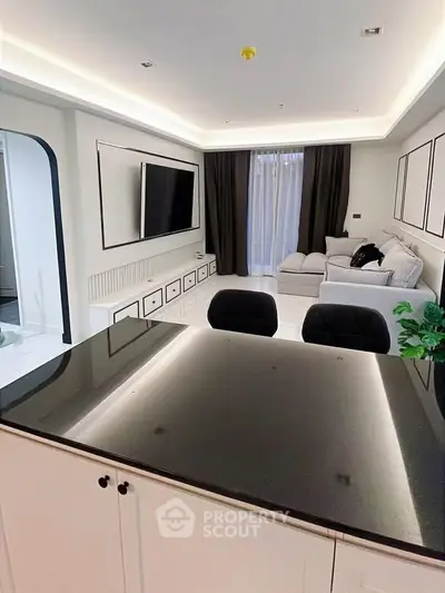 Modern living room with sleek design, featuring a large TV, comfortable sofa, and elegant lighting.