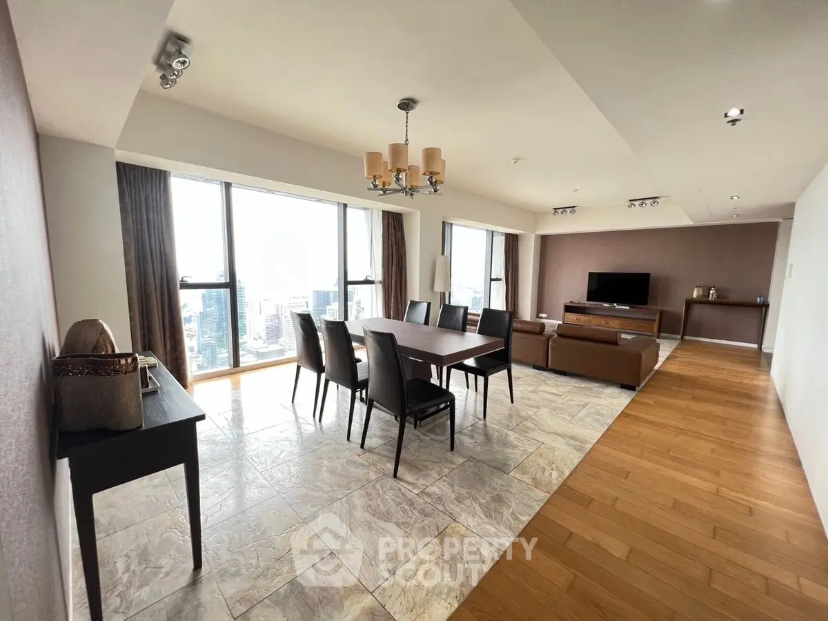 Spacious modern living and dining area with city view, featuring elegant furniture and natural light.