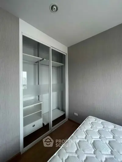 Modern bedroom with sleek built-in wardrobe and comfortable mattress, perfect for urban living.