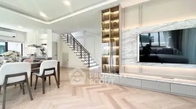 Luxurious open-plan living room with modern decor and elegant staircase