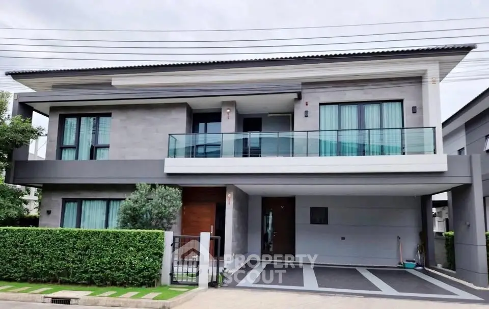 Modern two-story house with sleek design and spacious balcony in a serene neighborhood.