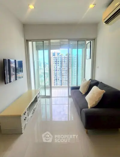 Modern living room with city view, sleek furniture, and large windows in high-rise apartment.